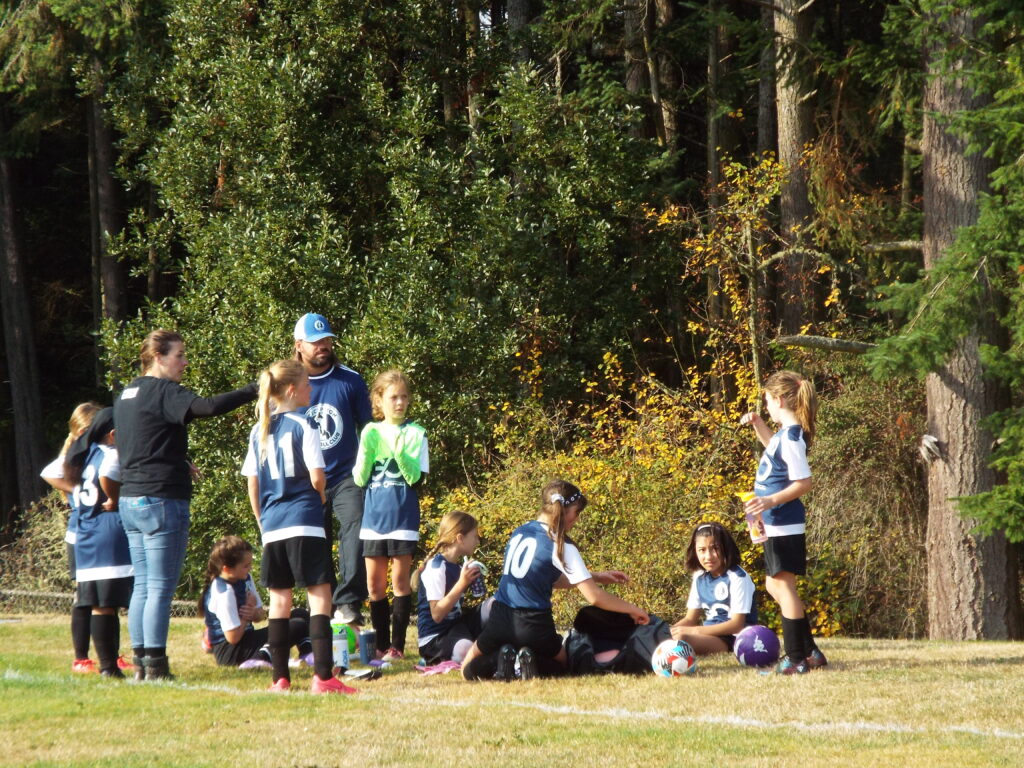 A group of soccer players listening to their coach.