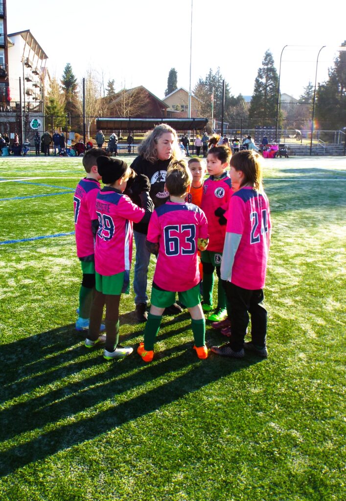 A group of soccer players listening to their coach.