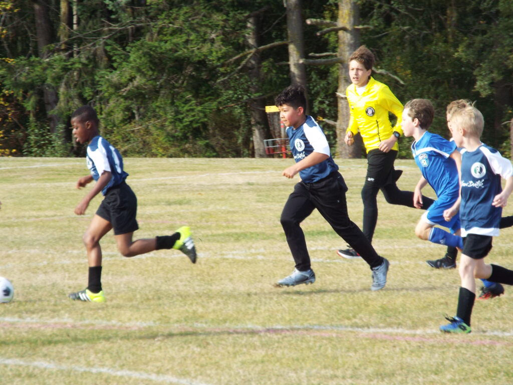 A referee running along with the game.