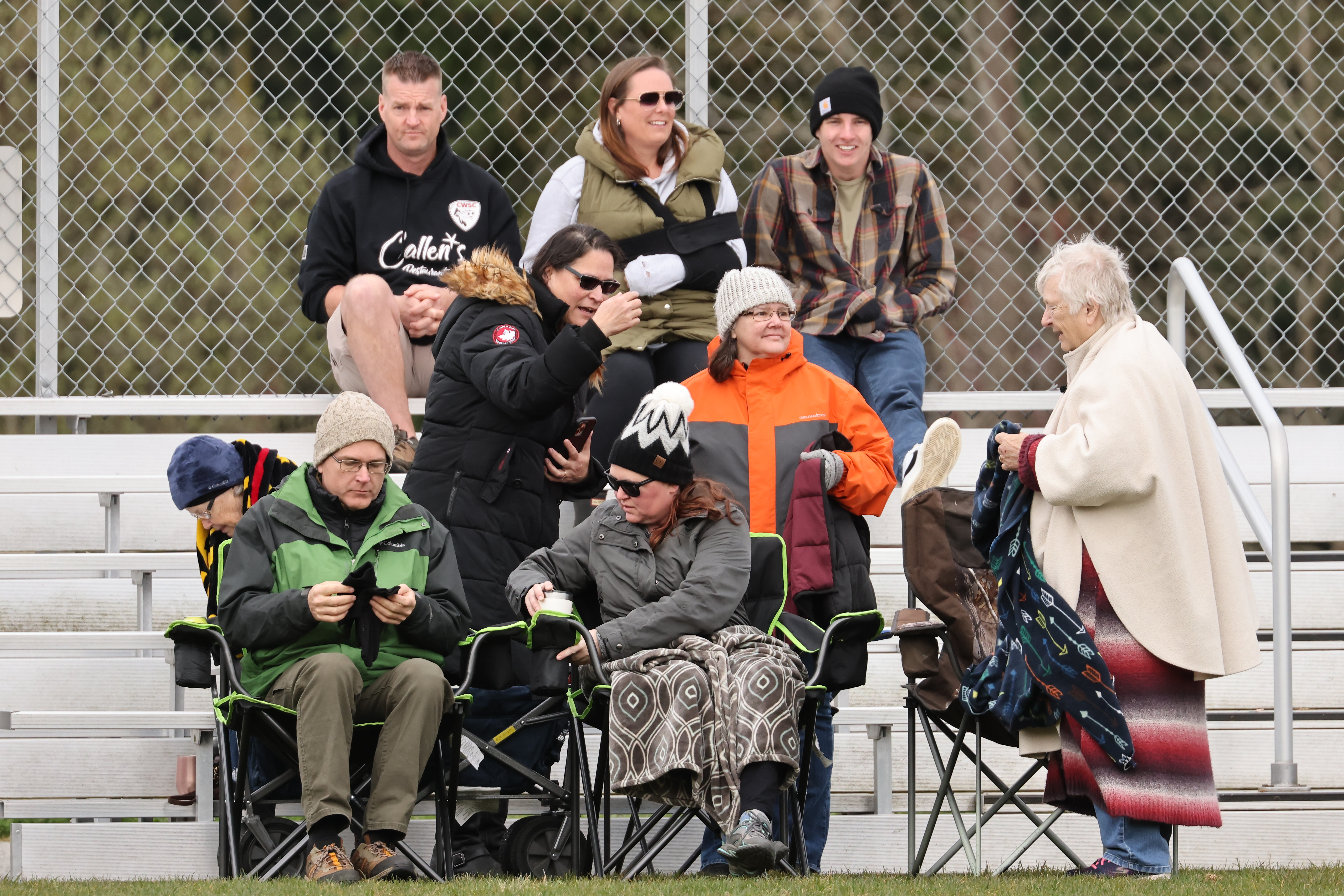 Group of parents of players gathered watching a game.